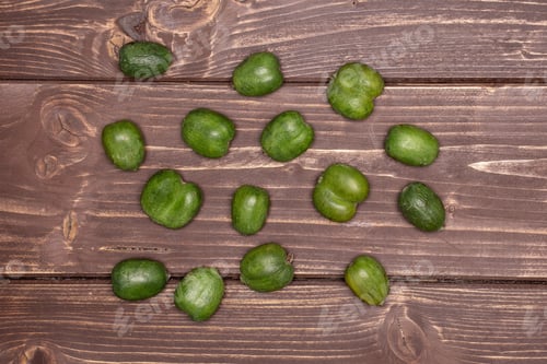 Preview: Lot Of Whole Fresh Green Mini Baby Kiwi Fruit Flatlay On Brown Wood