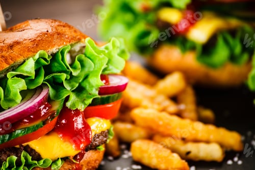 Preview: Tasty Cheeseburgers With French Fries Served On Black Stone