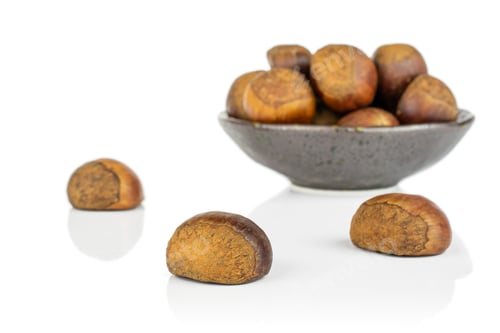 Preview: Lot Of Whole Sweet Brown Chestnut In Dark Ceramic Bowl Isolated On White Background