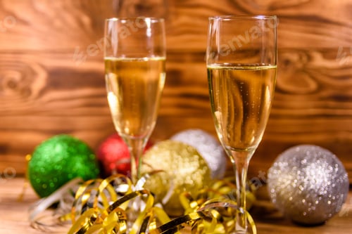 Preview: Two Wineglasses With Champagne And Different Christmas Decorations On Rustic Wooden Table
