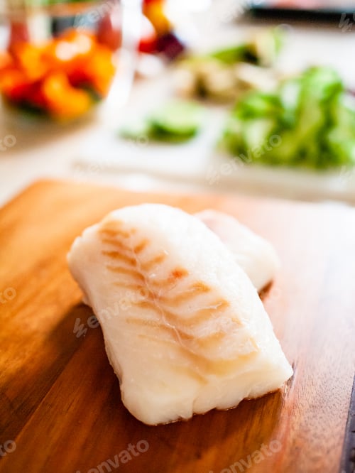 Preview: Fresh Raw Cod With Herbs And Vegetables Served On Cutting Board On Wooden Table