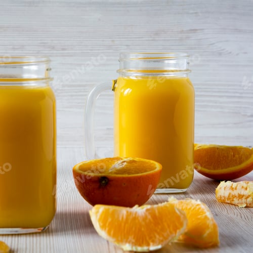 Preview: Homemade Fresh Orange Juice In Glass Jars Over White Wooden Background, Side View. Close-Up.