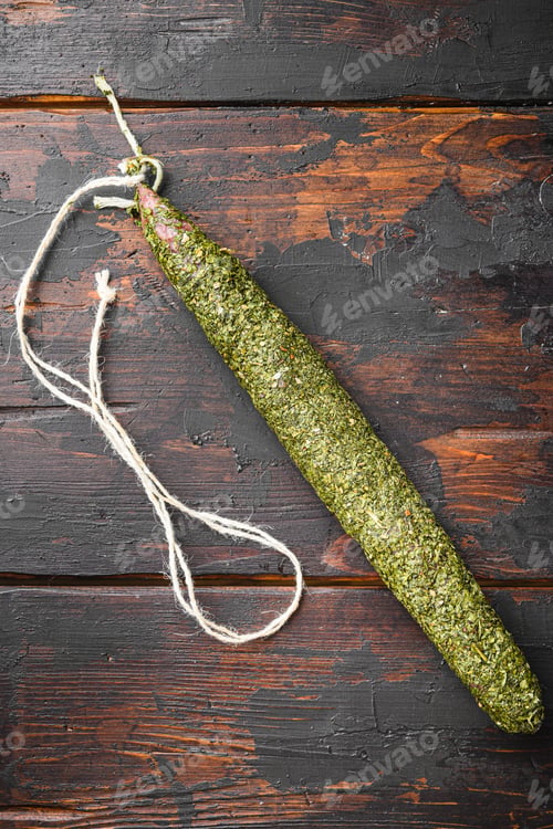 Preview: Fuet Sausage In Herbs On Dark Wood Background