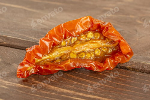Preview: One Slice Of Dry Red Cherry Tomato Macro On Brown Wood