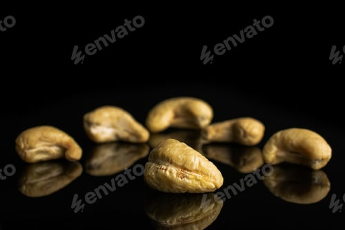 Preview: Group Of Six Whole Unsalted Beige Cashew Isolated On Black Glass