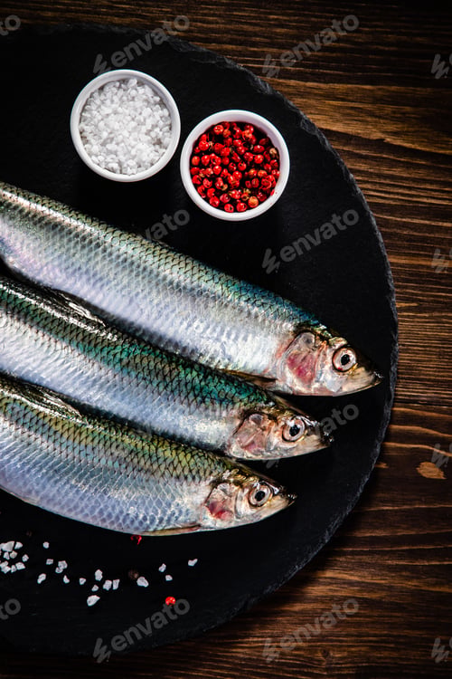 Preview: Fresh Raw Herrings Served On Black Stone On Wooden Table