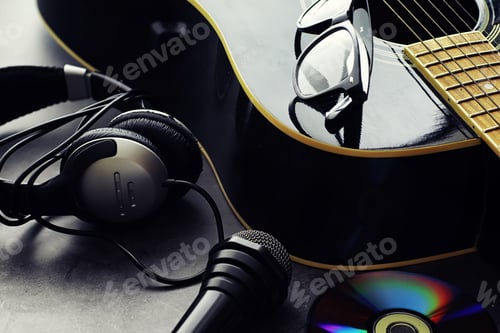 Preview: Guitar And Accessories On A Stone Background. Desk Musician, Headphones, Microphone And More.