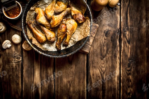 Preview: Fried Chicken Legs With Tomato Sauce. On A Wooden Table.
