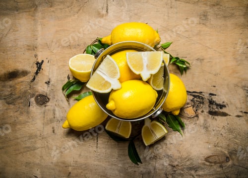 Preview: Fresh Lemons In A Bucket Of Leaves. On A Wooden Table. Top View