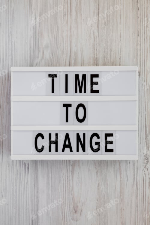 Preview: 'Time To Change' Words On A Lightbox Over White Wooden Background, Top View. Overhead, From Above