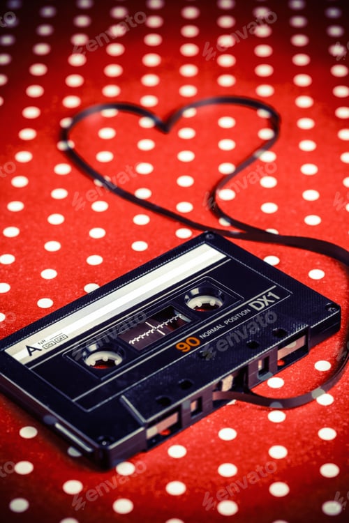 Preview: Audio Cassette With Magnetic Tape In Shape Of Heart On Red Dot Polka Background