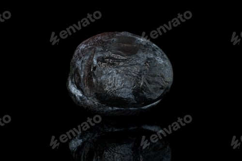 Preview: One Whole Drying Dark Blue Plum Isolated On Black Glass