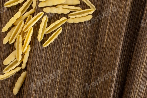 Preview: Lot Of Whole Uncooked Pasta Cavatelli Copyspace Flatlay On Brown Textured Cloth