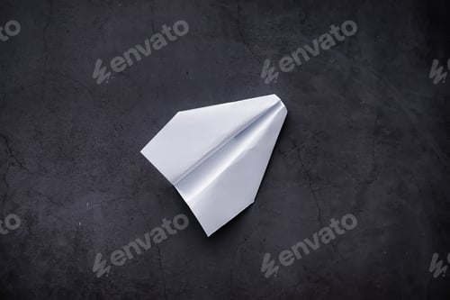 Preview: Paper Airplane On The Table. Origami Model On A Dark Background. Concept. Creative Waste Time.
