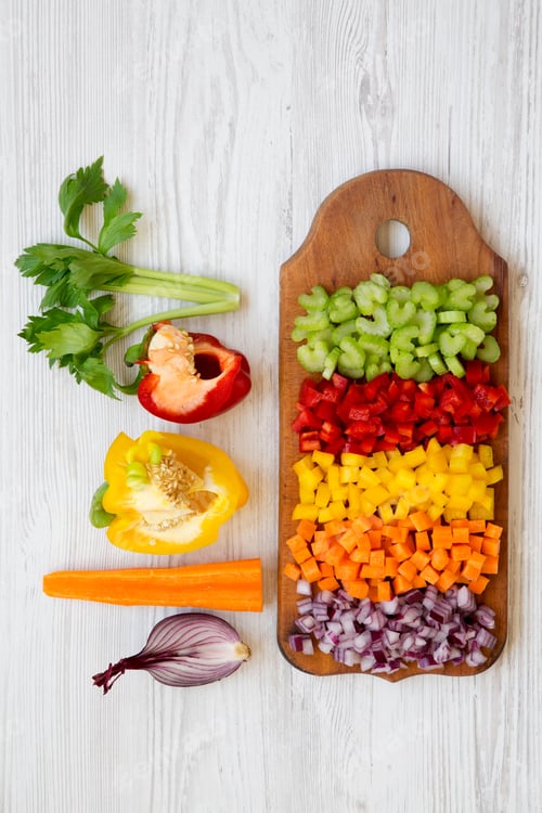 Preview: Chopped Fresh Vegetables (Carrot, Celery, Onion, Colored Peppers) Arranged On Cutting Board On