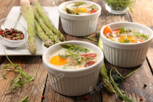 Preview: Baked Egg With Asparagus And Cream On Wood Background