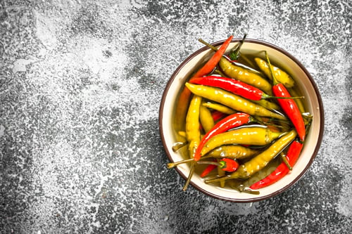 Preview: Pickled Chili Peppers In A Bowl. On A Rustic Background.