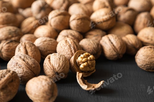 Preview: Halved And Whole Walnuts On Black Background, Side View. Close-Up. Selective Focus.