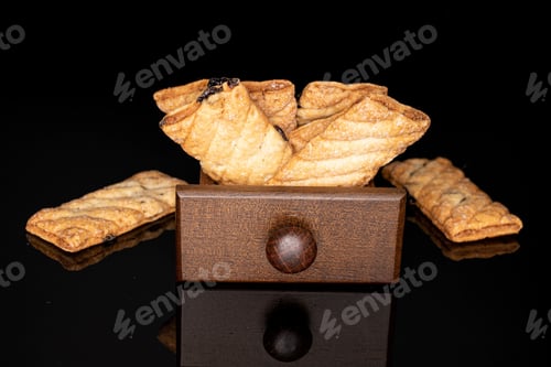 Preview: Lot Of Whole Square Puff Cookie With Raisins In Box Isolated On Black Glass