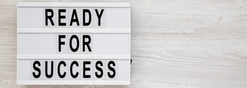 Preview: Top View, 'Ready For Success' Words On A Lightbox On A White Wooden Background. Overhead, From