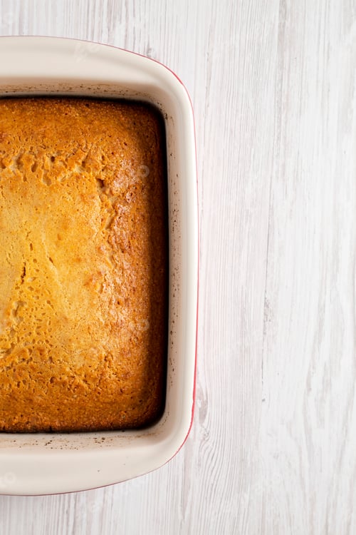 Preview: Homemade Sweet Cornbread In A Dish Over White Wooden Background, Top View. Flat Lay, Overhead, From