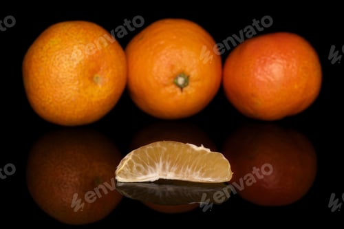 Preview: Group Of Three Whole One Piece Of Fresh Orange Mandarin Isolated On Black Glass