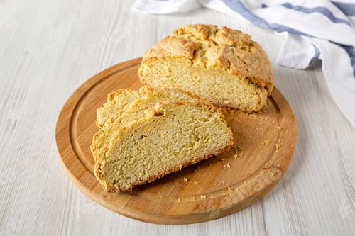 Preview: Homemade Irish Soda Bread On A Bamboo Board On A White Wooden Table, Side View. Close-Up.
