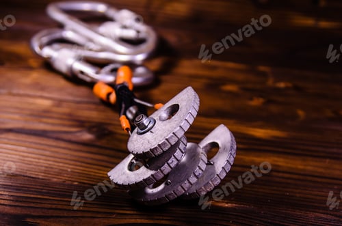 Preview: Camming Device Friend And Carabines For Rock Climbing On Rustic Wooden Table
