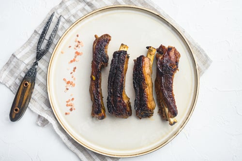 Preview: Grilled Pork Rib Set, On Plate, With Barbeque Knife And Meat Fork, On White Stone Background, Top