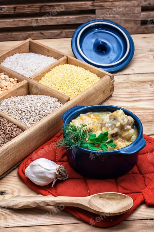 Preview: Wooden Box With Varieties Of Cereals On The Background Of The Cooked Pilaf.