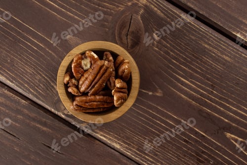 Preview: Lot Of Whole Fresh Brown Pecan Nut Half Copyspace On Right In A Wooden Bowl Flatlay On Brown Wood
