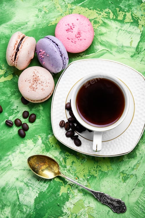 Preview: Coffee And Colorful French Macaroons On Green Background