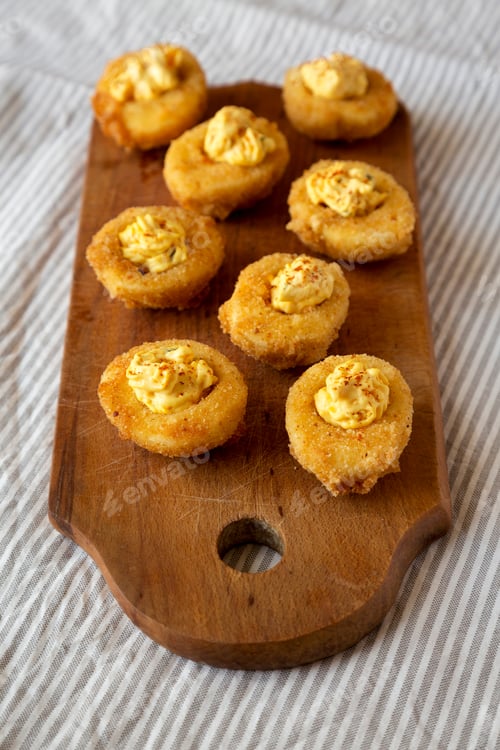 Preview: Homemade Deep-Fried Deviled Eggs With Paprika On A Rustic Wooden Board, Low Angle View.