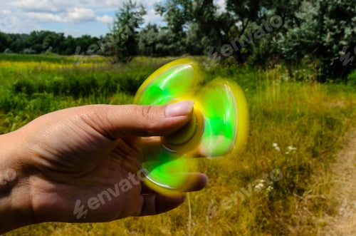 Preview: Yellow Fidget Spinner Rotates In A Female Hand