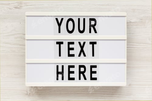 Preview: 'Your Text Here' Words On A Lightbox On A White Wooden Background, Top View.