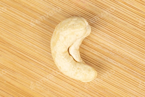 Preview: One Whole Brown Nut Cashew Flatlay On Light Wood