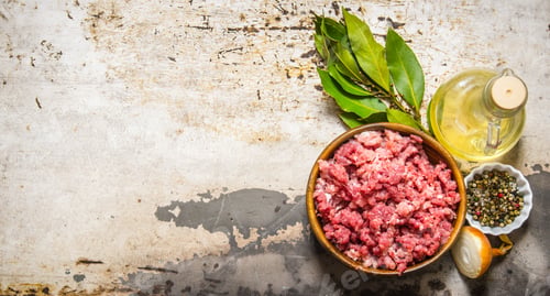 Preview: Minced Meat In A Wooden Bowl With Spices And Oil. On Rustic Background. Free Space For Text . Top