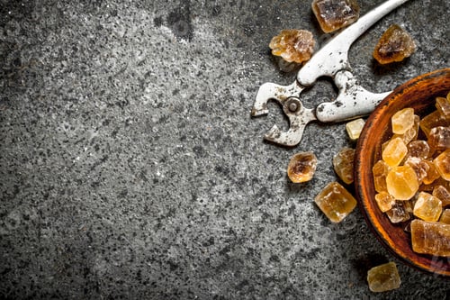 Preview: Crystals Of Cane Sugar In A Bowl. On A Rustic Background.