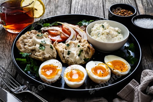 Preview: Delicious Breakfast - Soft Boiled Eggs With Cottage Cheese And Vegetables Served On Black Plate On