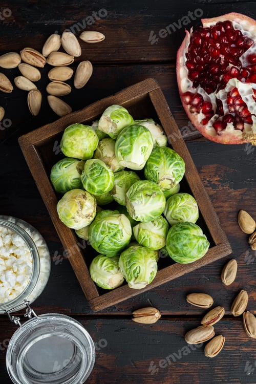 Preview: Brussels Sprouts With Pomegranate, Cottage Cheese And Pistachios, On Old Wooden Table, Flat Lay