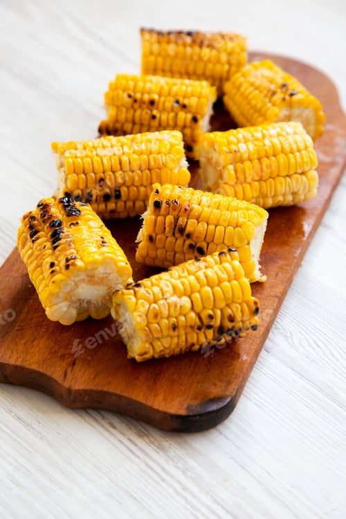 Preview: Tasty Grilled Corn On The Cob On Wooden Board Over White Wooden Background, Side View. Summer Food.