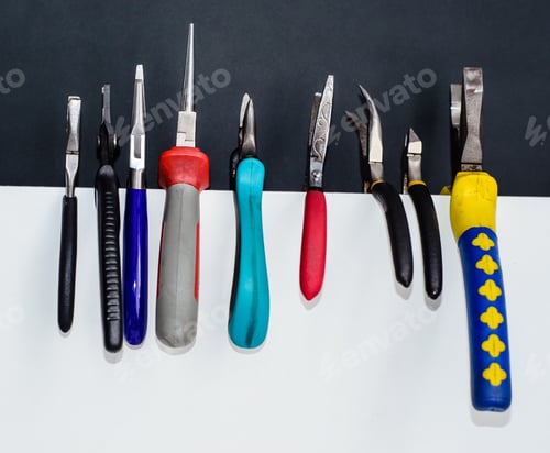 Preview: Different Nippers And Pliers On A White Chipboard