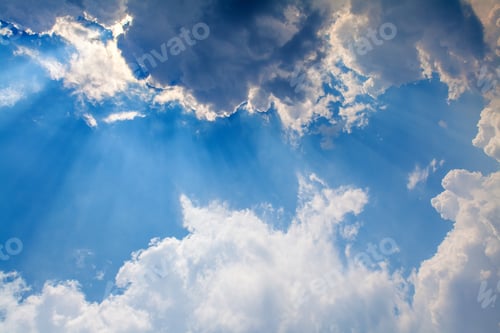 Preview: Sun Rays Streaming Through Fluffy Clouds in Blue Sky