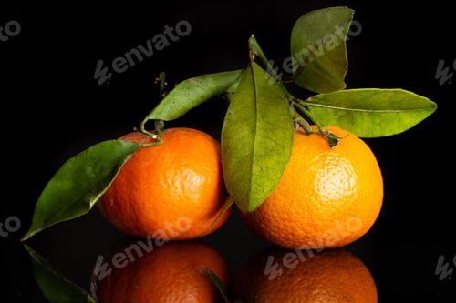 Preview: Group Of Two Whole Bright Fresh Orange Mandarine With Green Leaves Isolated On Black Glass