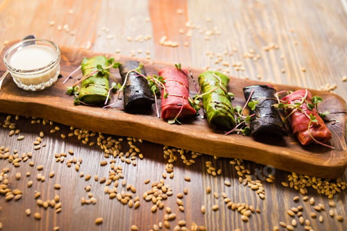 Preview: Some Colored Pancakes Roll With White Sauce On Wooden Board