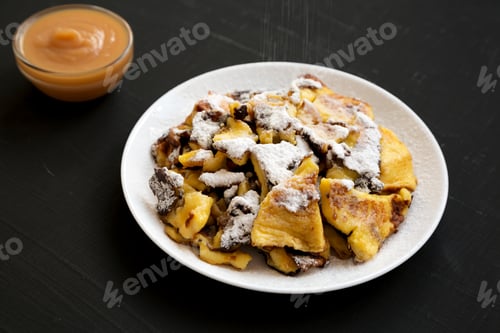 Preview: Homemade German Kaiserschmarrn Pancake On A Black Surface, Side View. Closeup.