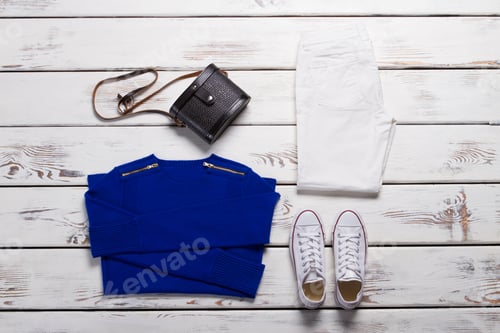 Preview: Folded Sweatshirt And White Shoes. Black Purse And Blue Pullover. Stylish Female Outfit For Autumn