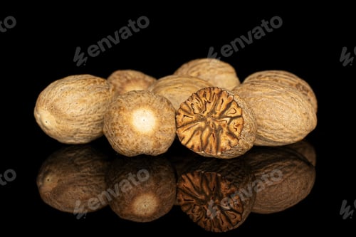 Preview: Group Of Six Whole One Half Of Dry Brown Nutmeg Isolated On Black Glass