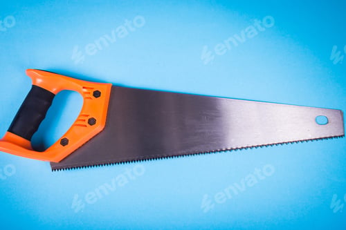 Preview: Hacksaw With Orange Plastic Handle On The Blue Surface In The Studio