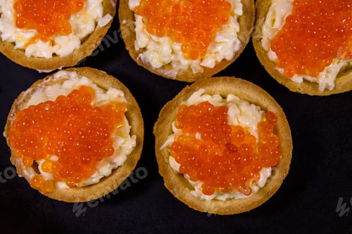 Preview: Tartlets With Red Caviar On Black Plate. Festive Food. Top View